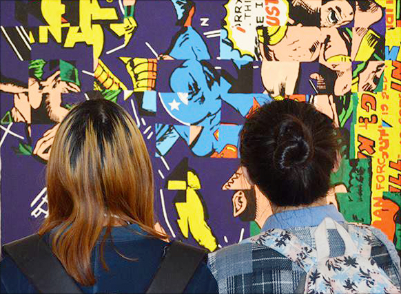 Two students looking at colorful painting