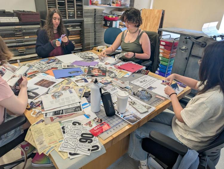 students clipping from magazines spread across a work table