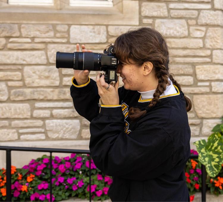 Girl holding camera and taking a photo