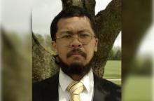 man with tie standing in front of tree