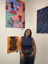 Ja'Licia Gainer, Artist standing in front of her paintings