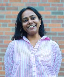 Muditha Pathirana standing in front of a multi colored brick wall